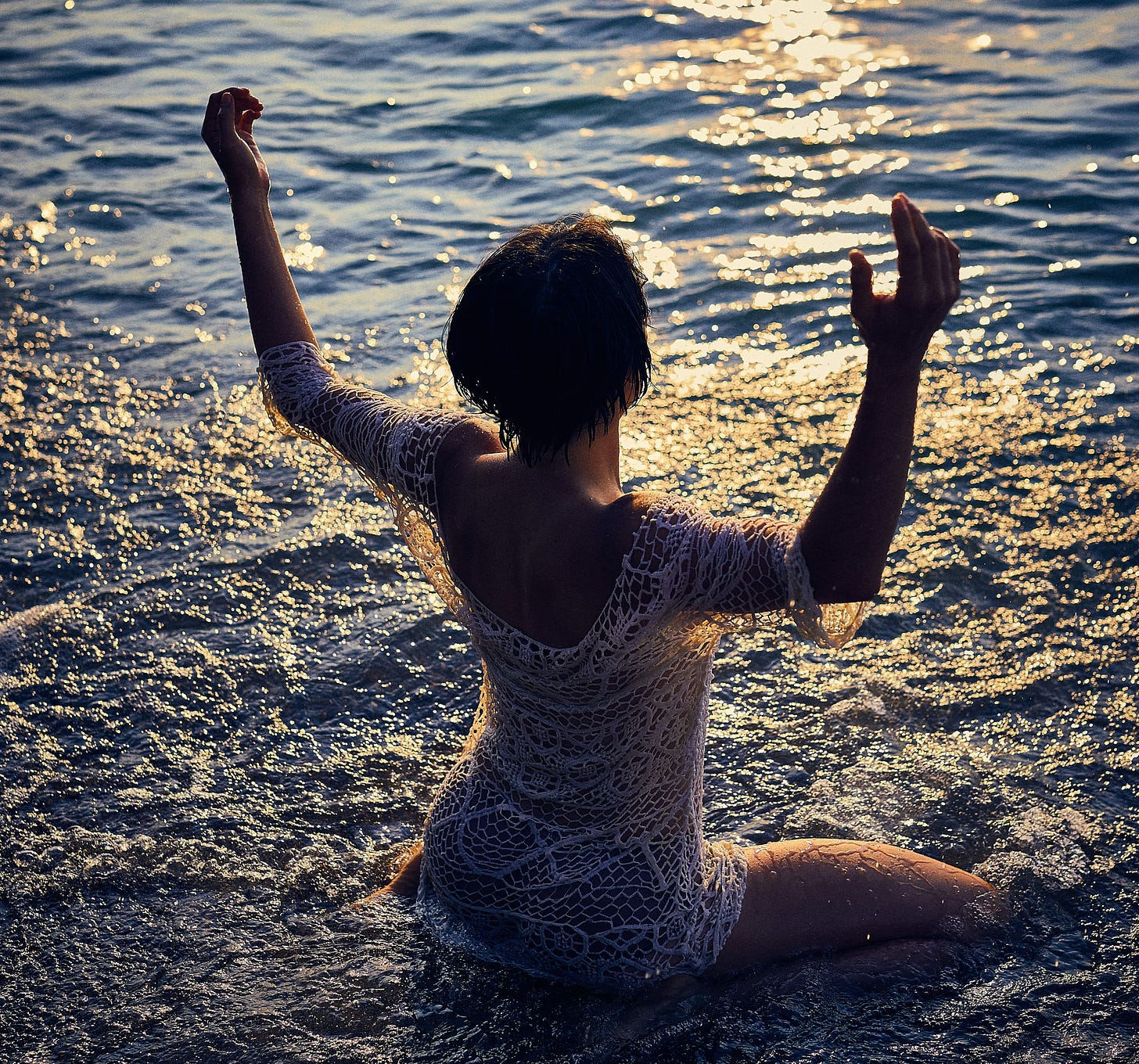 Woman raising hands in peace ocean