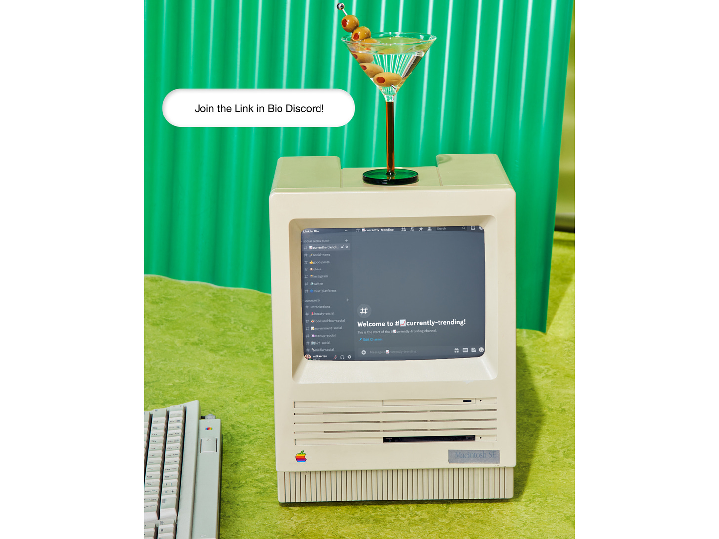 Photo of an old computer with a Discord screenshot comped in. There is also a martini sitting on top.