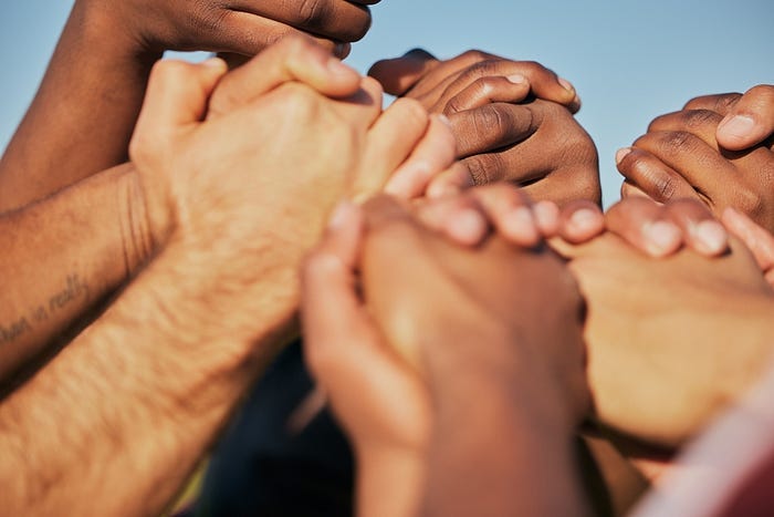 Closeup, teamwork and Jewish and Black people holding hands, cooperation and support with empowerment. Diversity, group and friends with activity, strong together and motivation with union, human and collaboration