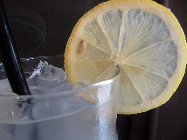 Lemonade made with sauerkraut brine--rim of glass with icy liquid and lemon round