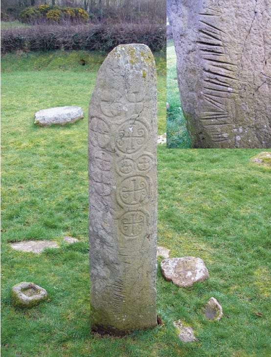 Photo of the Kilnasaggart pillar stone in County Armagh. It's an upstanding pillar with a number of crosses carved into it. An inset detail shows some of the 55 grooves carved into it, apparently by swords.