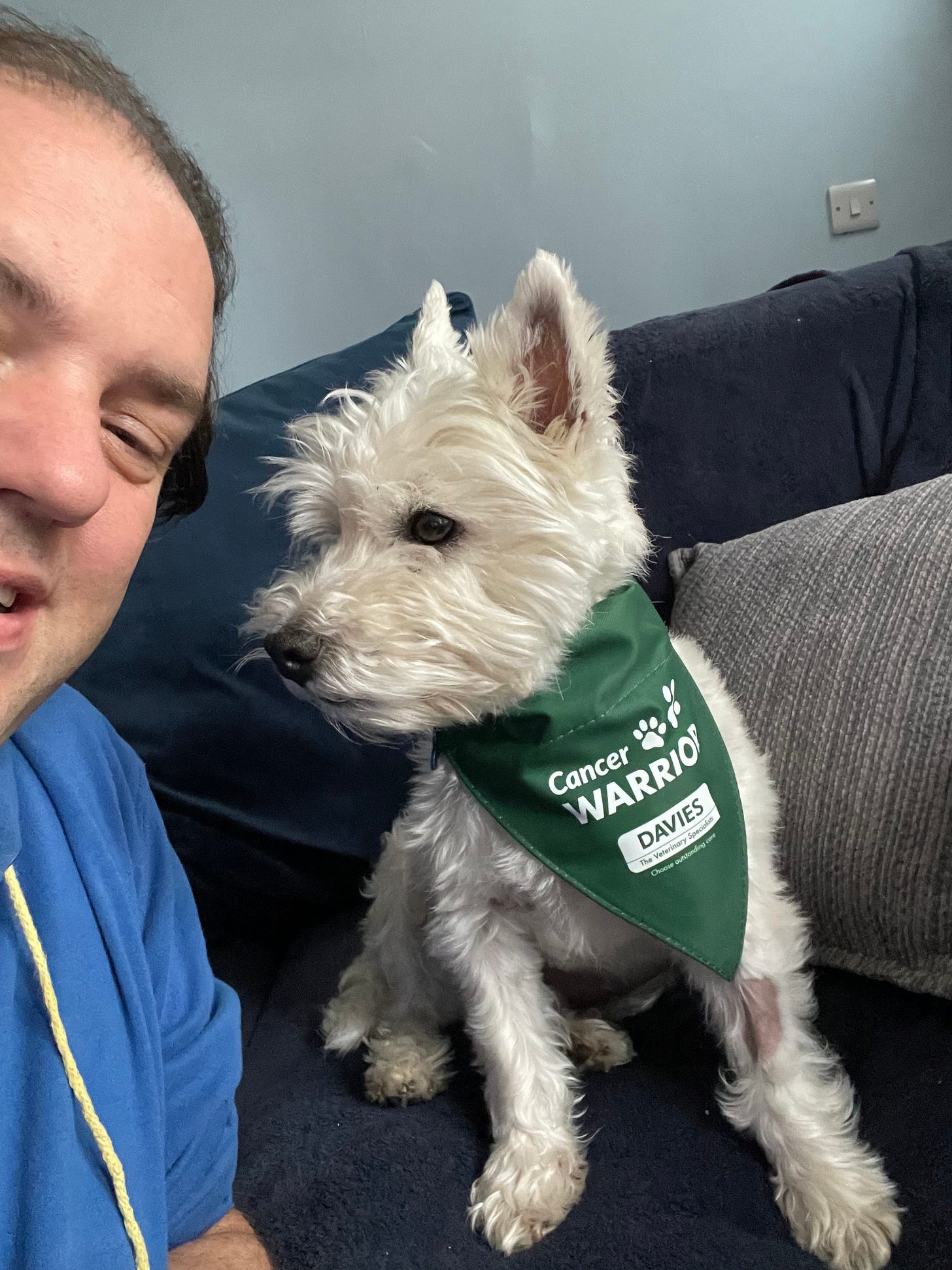 my and my west highland terrier. he is wearing a bib that says cancer warrior