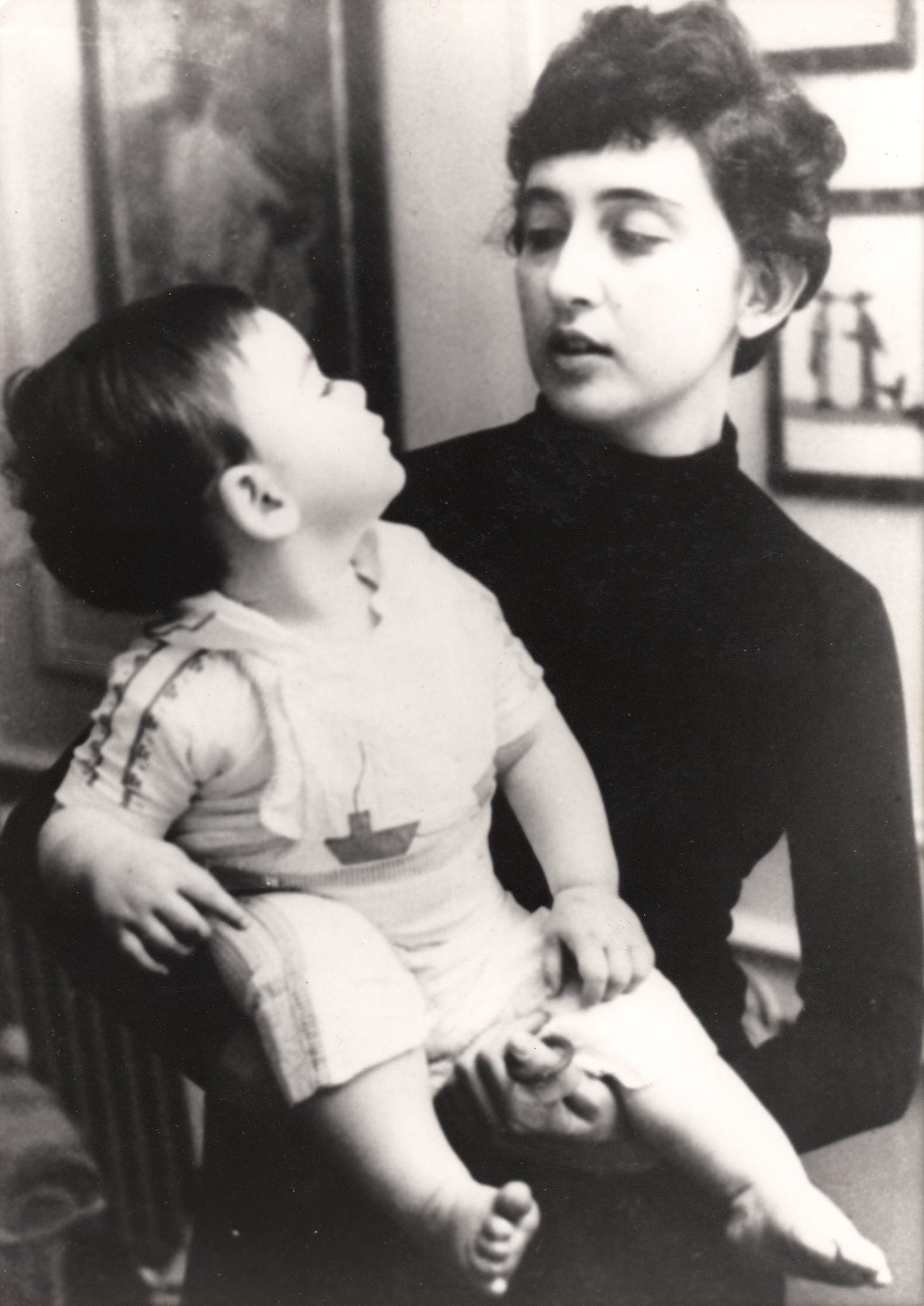 My beautiful mom, in her early 30s, holding baby me. We are looking into each other's eyes.