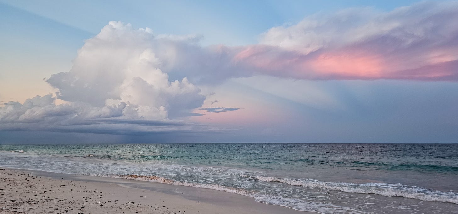 Blue and pink sunset with storm clouds over the beach in Tulum, Mexico.