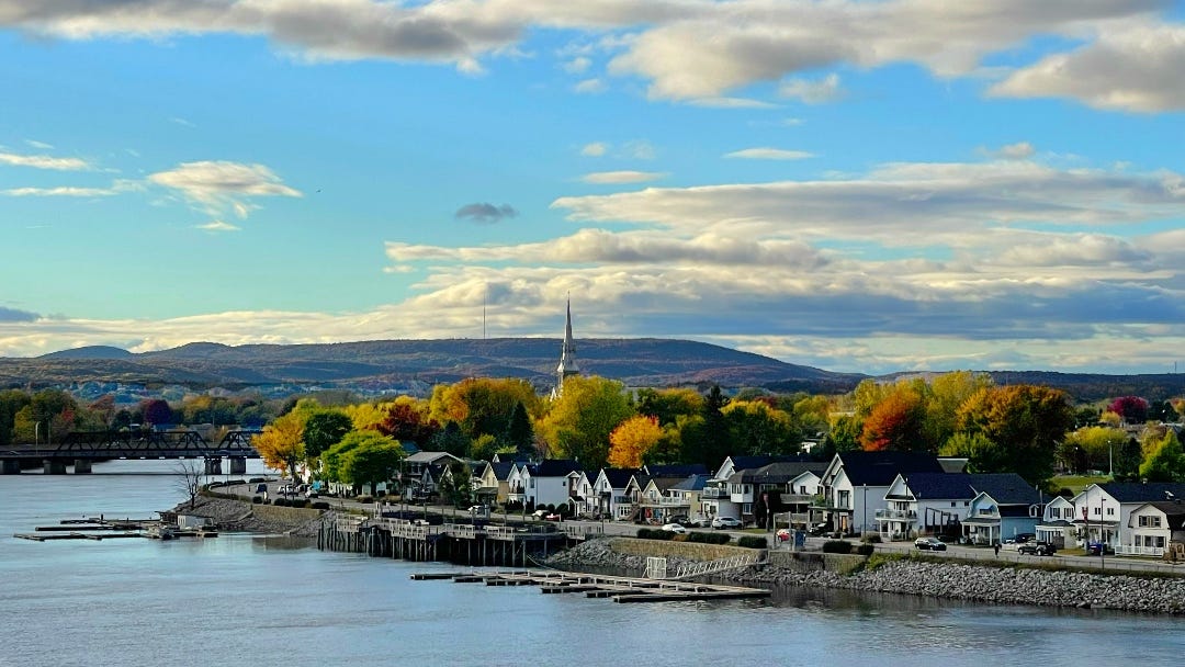 A view on Quebec on the other side of the river, with houses along the Ottawa River and colorful trees