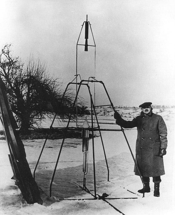 Robert Goddard, bundled against the cold weather of March 16, 1926, holds the launching frame of his most notable invention — the first liquid-fueled rocket. Robert Goddard, bundled against the cold weather of March 16, 1926, holds the launching frame of his most notable invention — the first liquid-fueled rocket.
