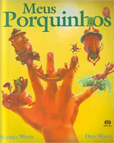 Capa do livro “Meus porquinhos”, Audrey Wood e Don Wood. Num fundo amarelo, uma mão aberta traz um porquinho em cada dedo
