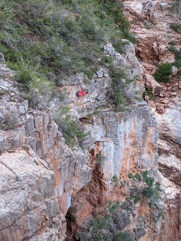 A hammock hanging at the top of a sheer cliff that is the top of the Grand Canyon
