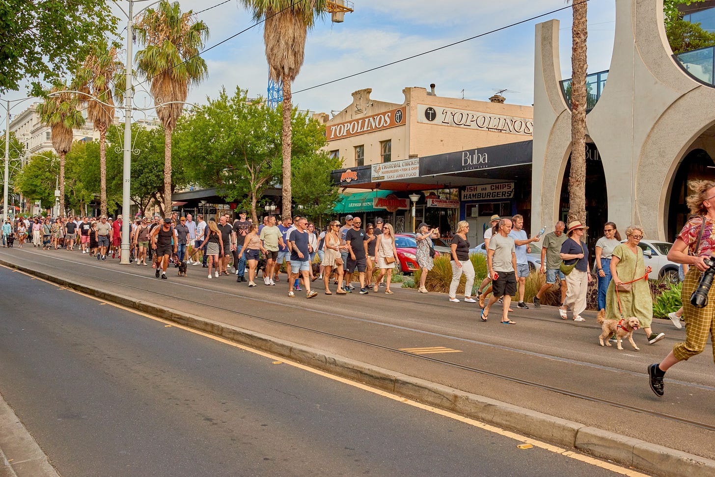 May be an image of 7 people, road, street, crowd and text