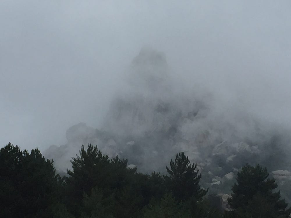 Rock peak partially hidden by clouds.