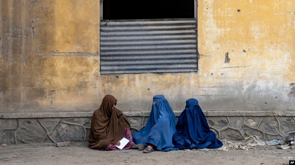 FILE- Afghan women wait to receive food rations distributed by a humanitarian aid group, in Kabul, Afghanistan, May 23, 2023. 