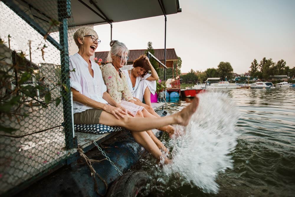 Senior female friends enjoying a day in the cottage near the river.