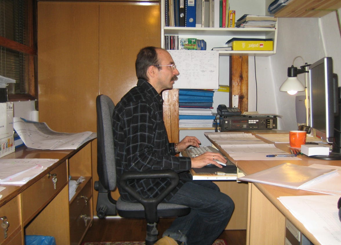 A photo of me behind a desk at work in a small office in 2008