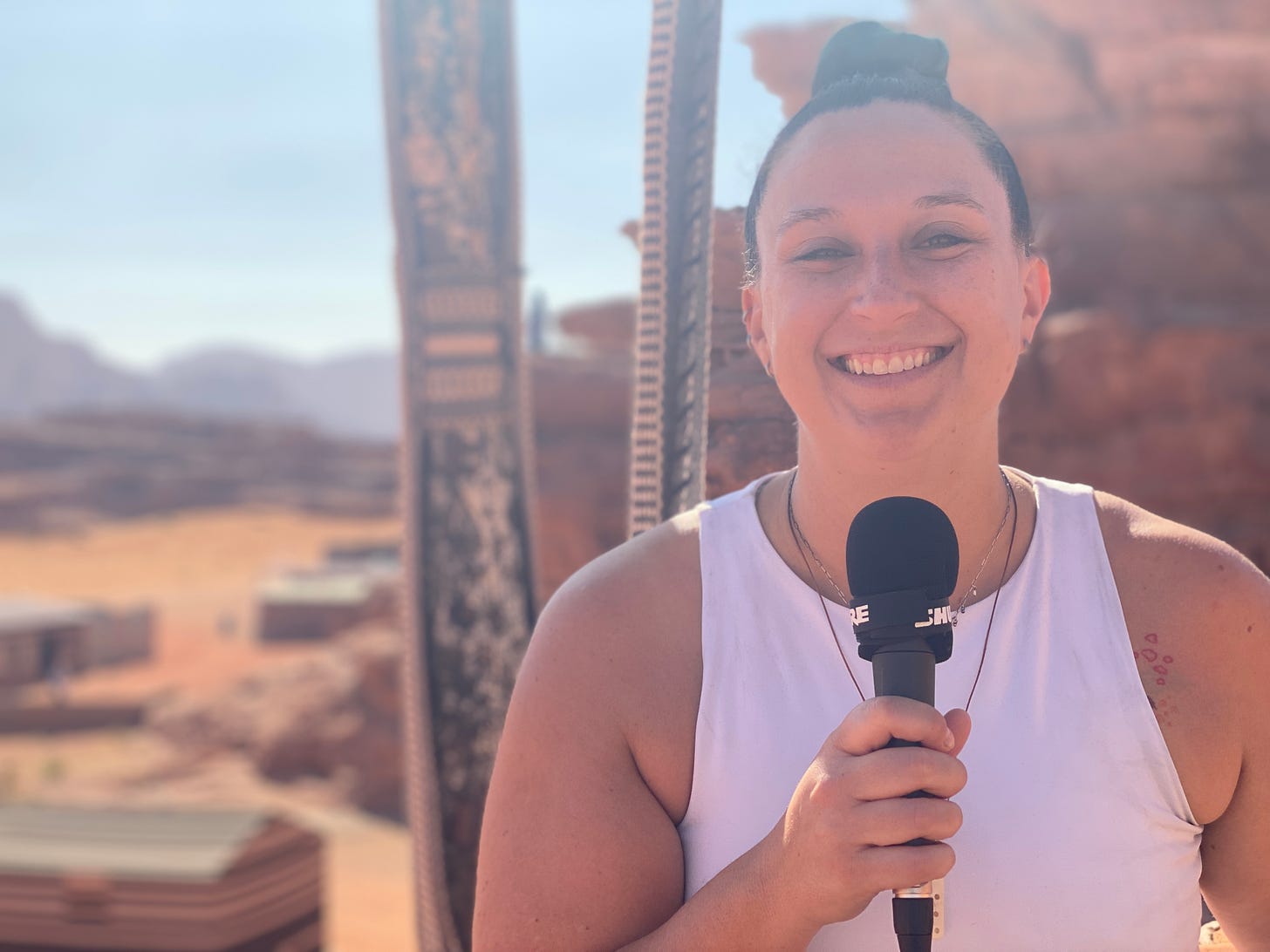 Helen holding a microphone with the desert behind her