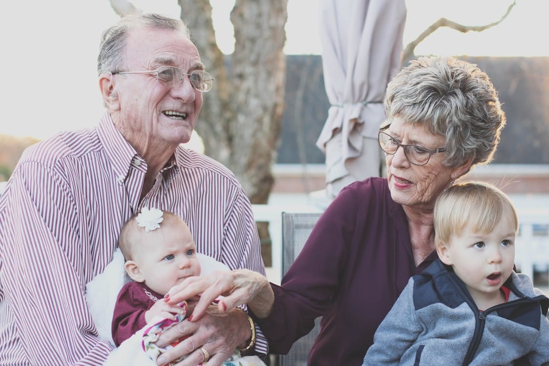 Free Grandparents spending joyful moments with their grandchildren in an outdoor setting, captured candidly. Stock Photo Free Grandparents spending joyful moments with their grandchildren in an outdoor setting, captured candidly. Stock Photo