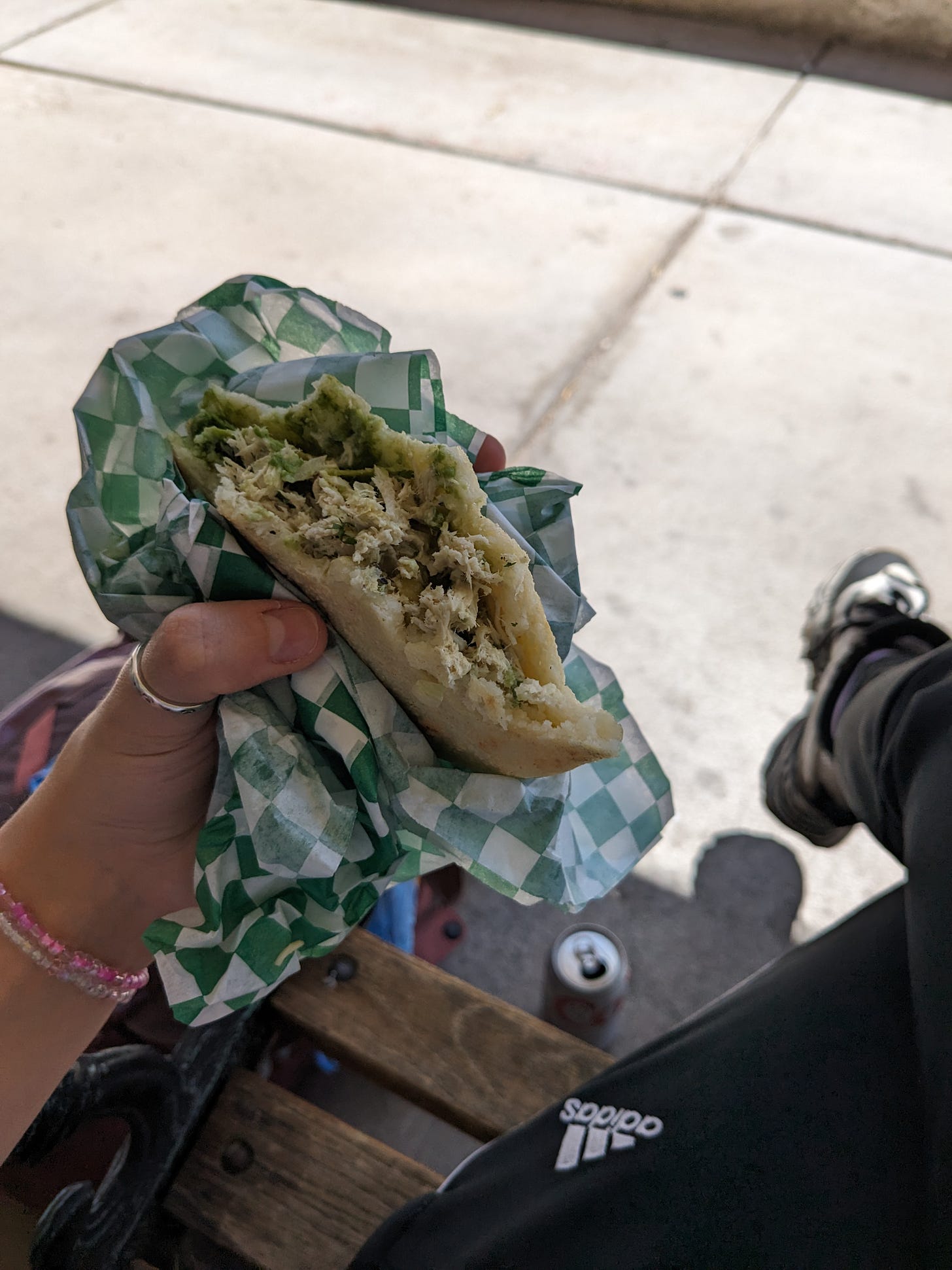 The best arepa I have ever eaten, here in my meaty claw on a bench.