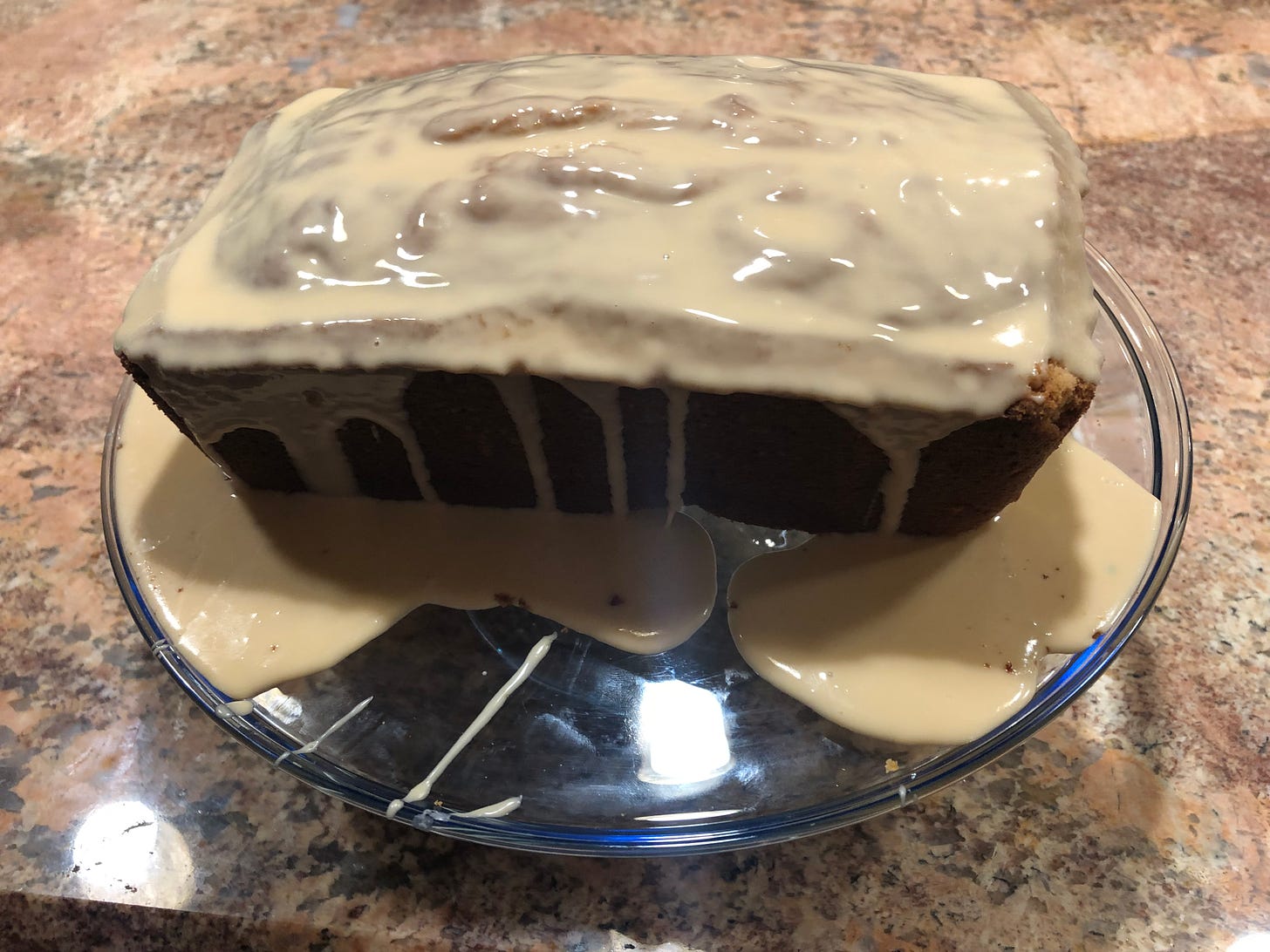 A loaf of pound cake with a caramel colored drizzle of icing.