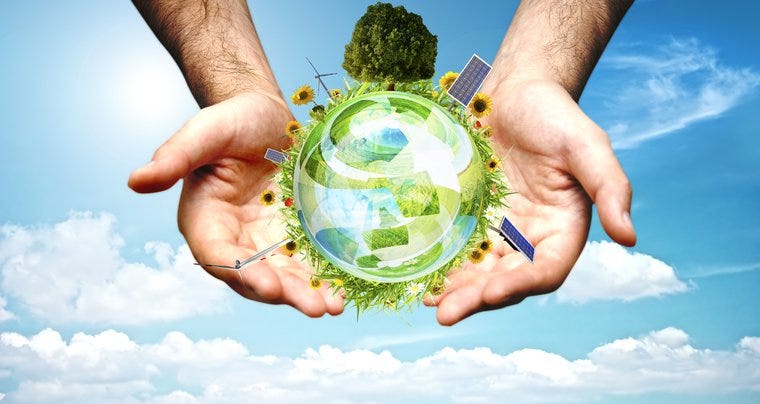 Image of two hands clutching a globe covered in plants, trees, and signs of sustainable infrastructure such as windmills and solar panels. The hands and globe are placed in front of a sunny, clear blue sky.