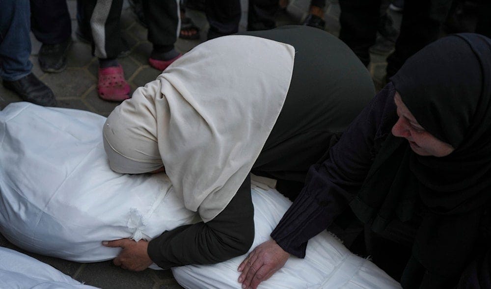 Mourners embrace the body of their relative who was killed in the Israeli bombardment of the Gaza Strip, during his funeral in Deir al-Balah, Wednesday, Jan. 15, 2025. (AP)