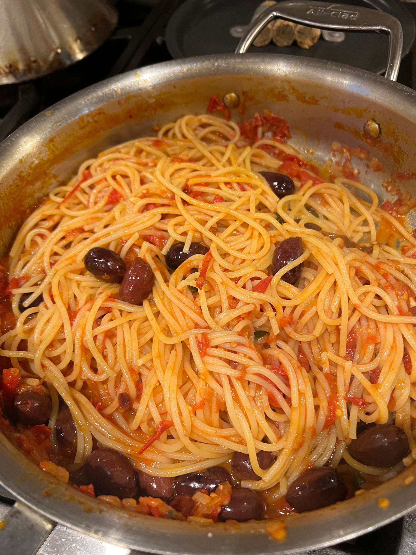 spaghetti with olives and capers in a pan