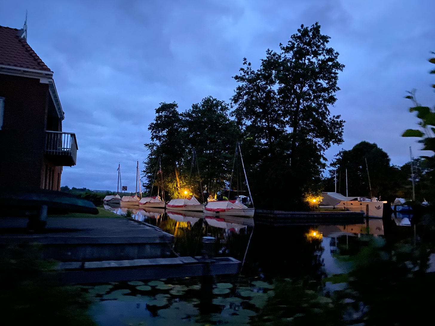 Small sailboats tied up in a Dutch harbor at night