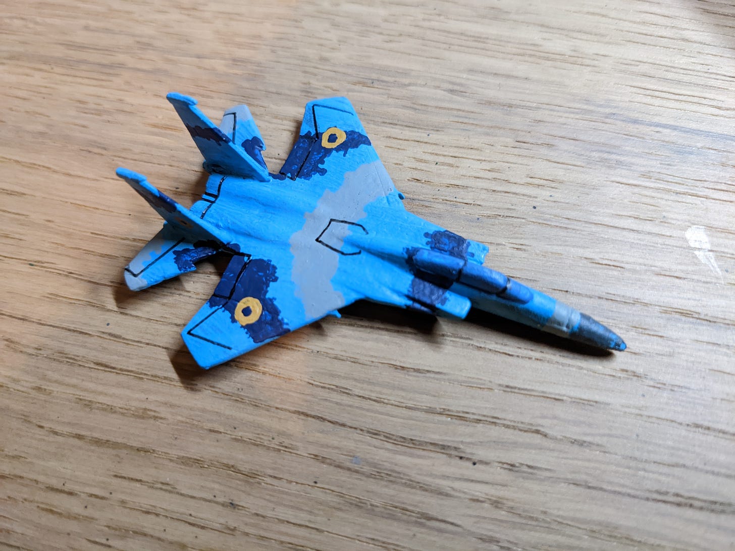 A 6 mm scale model of an F-15 fighter jet painted in the blue, grey and light blue of the Ukrainian Air Force