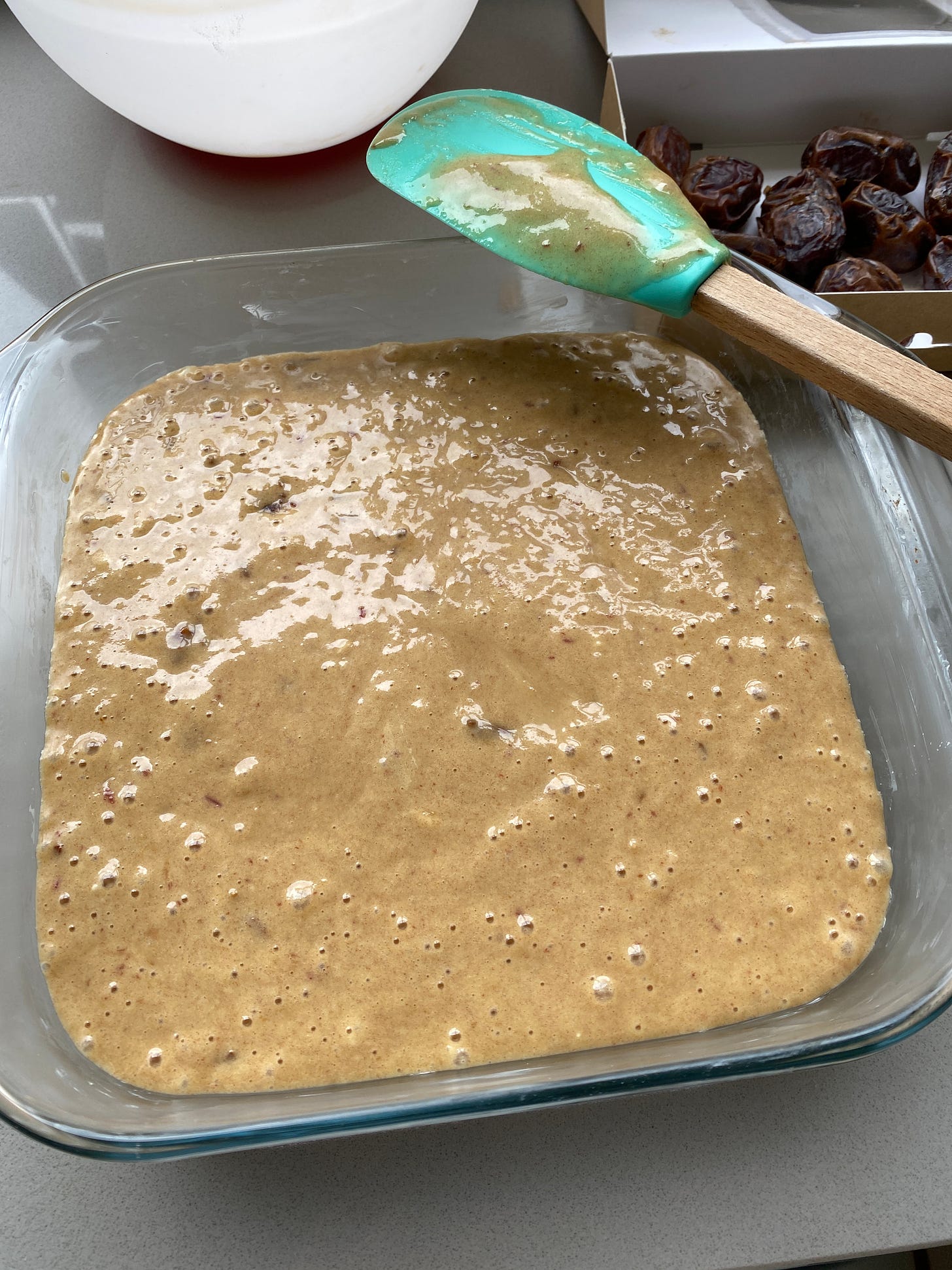 Toffee and Date Pudding in a glass dish with a slice cut out..