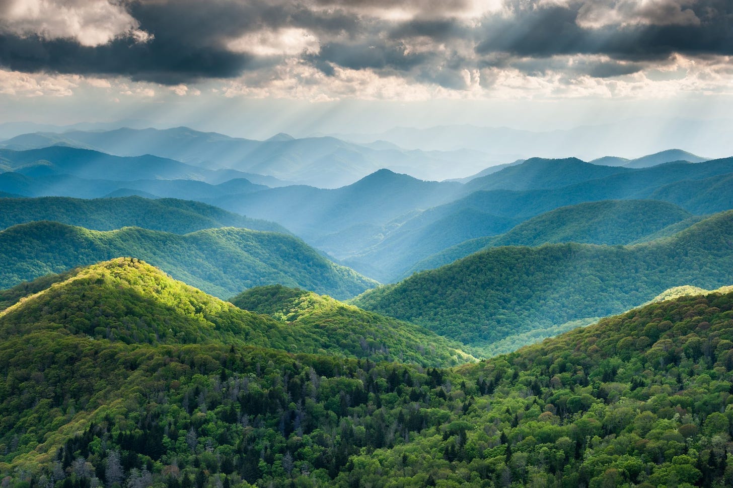 Beautiful photo of the Appalachian Mountains, sun rays breaking through a moody sky.