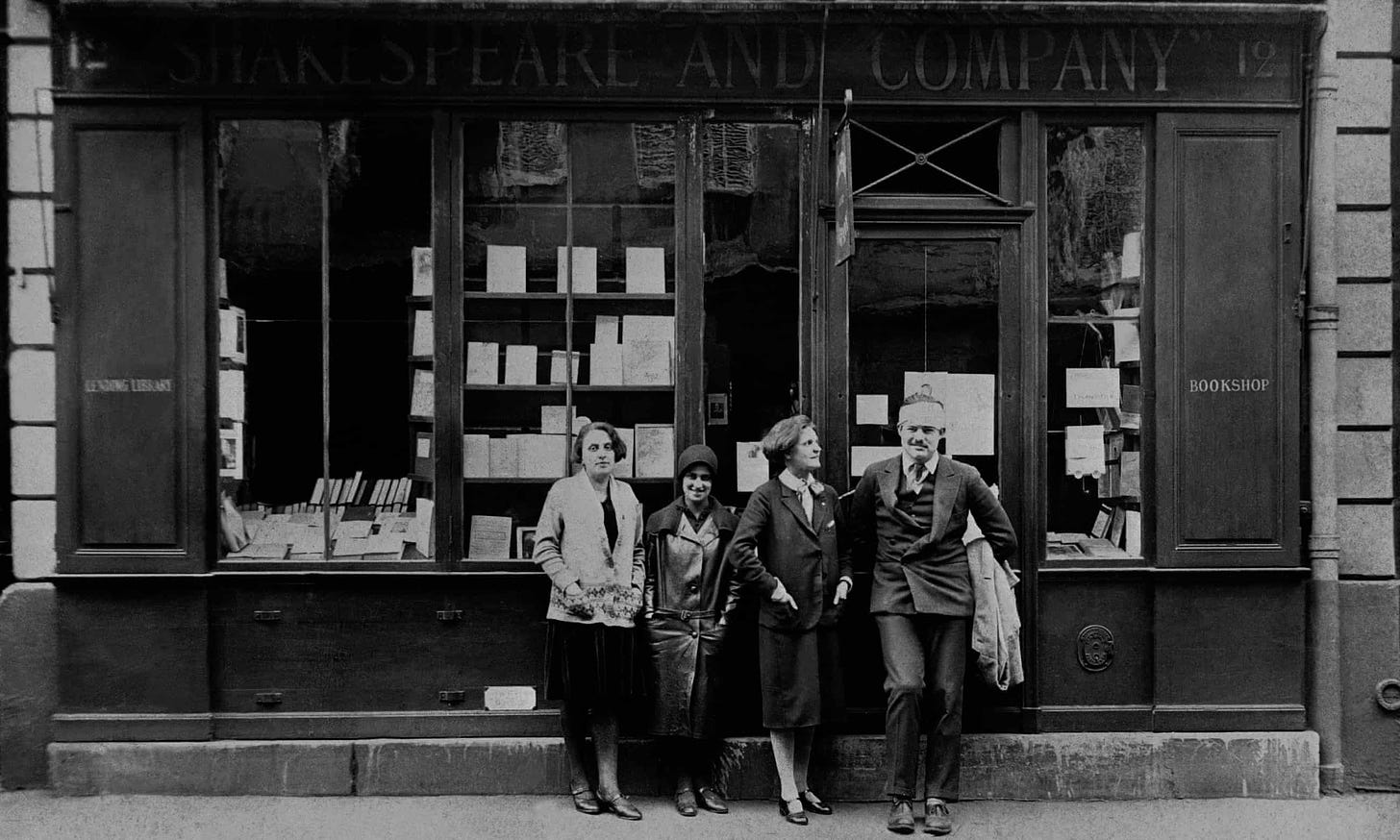 Sylvia Beach (terceira da esquerda para a direita) ao lado de Ernest Hemingway na livraria Shakespeare and Company em 1926.