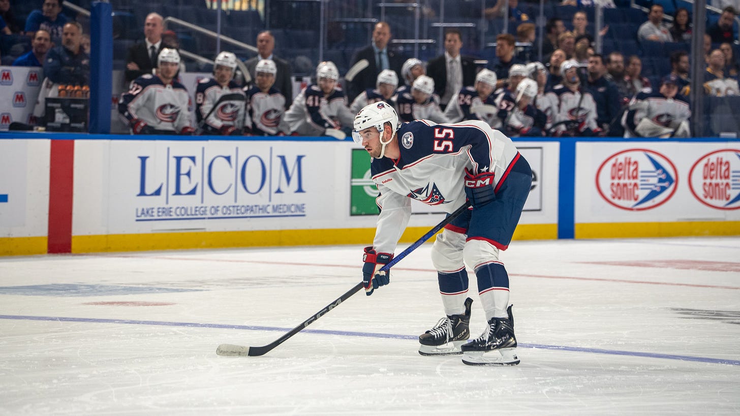 David Jiříček bending down with his hockey stick before a face-off in an NHL preseason game against the Buffalo Sabres.