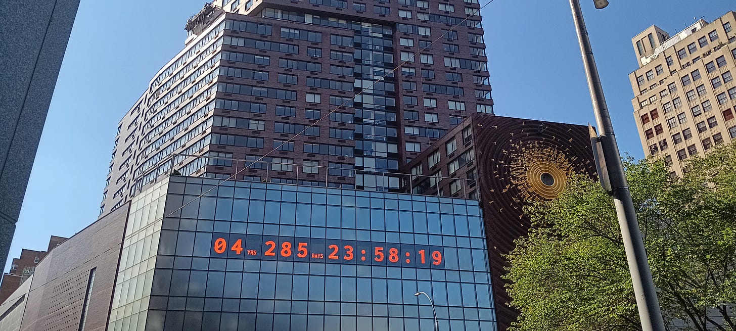 A large building in New York City that has a digital clock readout on it which reads: 04 years, 285 days, 28:53:19