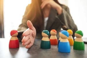 The picture shows a hand separating one child doll from a group of other dolls