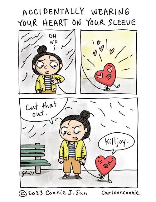 Accidentally Wearing Your Heart On Your Sleeve 3-panel comic of a cartoon girl with a bun and a plushy red cartoon heart, tied to her arm by a string. Heading reads "Accidentally Wearing Your Heart On Your Sleeve." Panel 1 is a close-up of the girl, looking down at the string around her wrist. She says, "Oh no," with a concerned expression on her face. Panel 2 is a close-up of plushy heart, radiating unfettered joy. Panel 3 shows both in the same frame. The girl looks at the heart reproachfully and says, "Cut that out." Indifferently, the heart accuses her of being a "Killjoy." Original comic strip by Connie Sun, cartoonconnie, 2023.