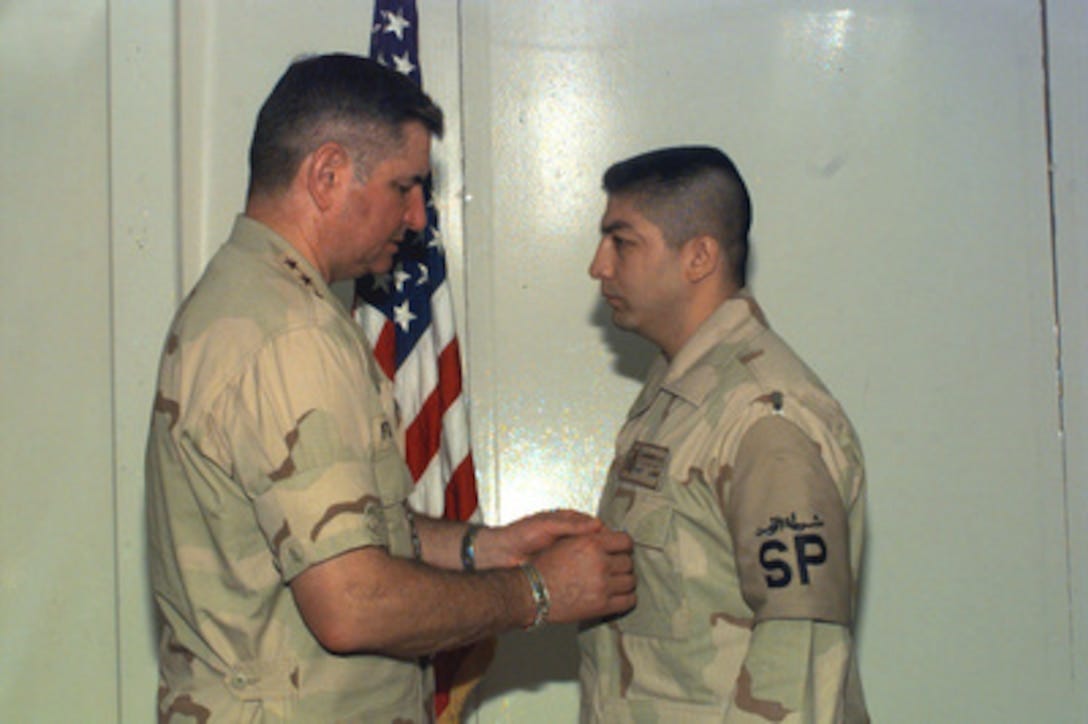 U.S. Air Force Chief of Staff Gen. Ronald R. Fogleman (left) presents the Airman's Medal to security policeman Staff Sgt. Alfredo R. Guerrero on July 3, 1996, in Saudi Arabia. Guerrero began evacuating the top two floors of Building 131 at Khobar Towers after spotting the terrorist truck that exploded 3 1/2 minutes later. After the explosion, Guerrero continued to evacuate the wounded and assisted with CPR and First Aid. The explosion outside the northern fence of the Khobar Towers complex near King Abdul Aziz Air Base on June 25, 1996, killed 19 and injured over 260. Guerrero, a Modesto, Calif., native, is deployed to Saudi Arabia from Edwards Air Force Base, Calif. 