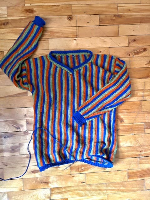 A vertical striped v-neck sweater in blue, orange, and green