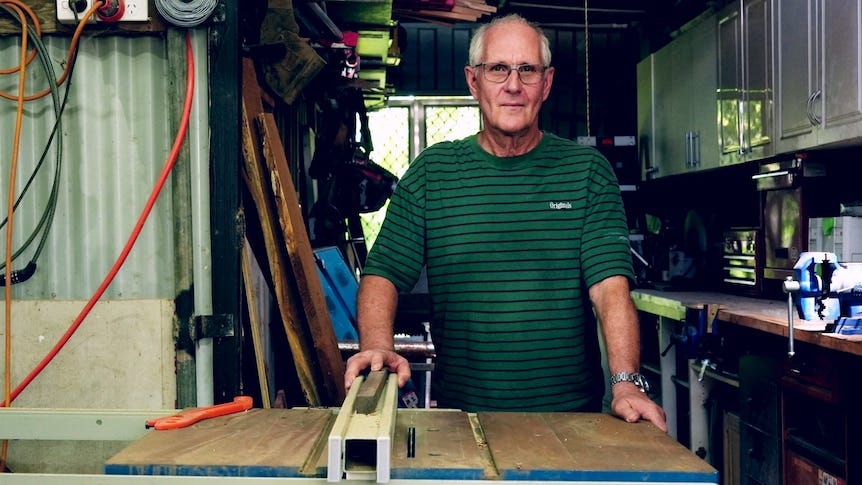 A man in his 60s in a backyard work shed