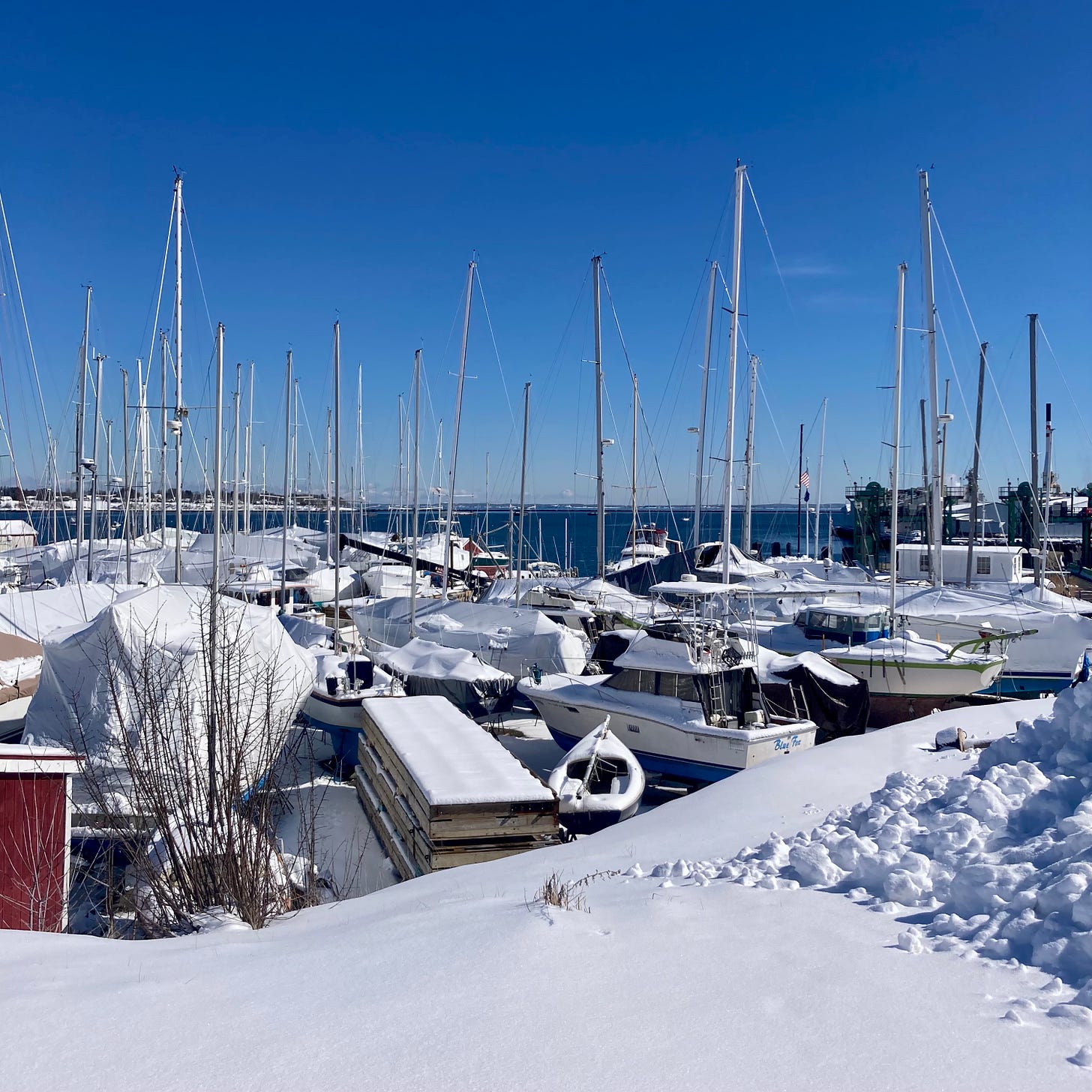 A group of boats on land in snow.