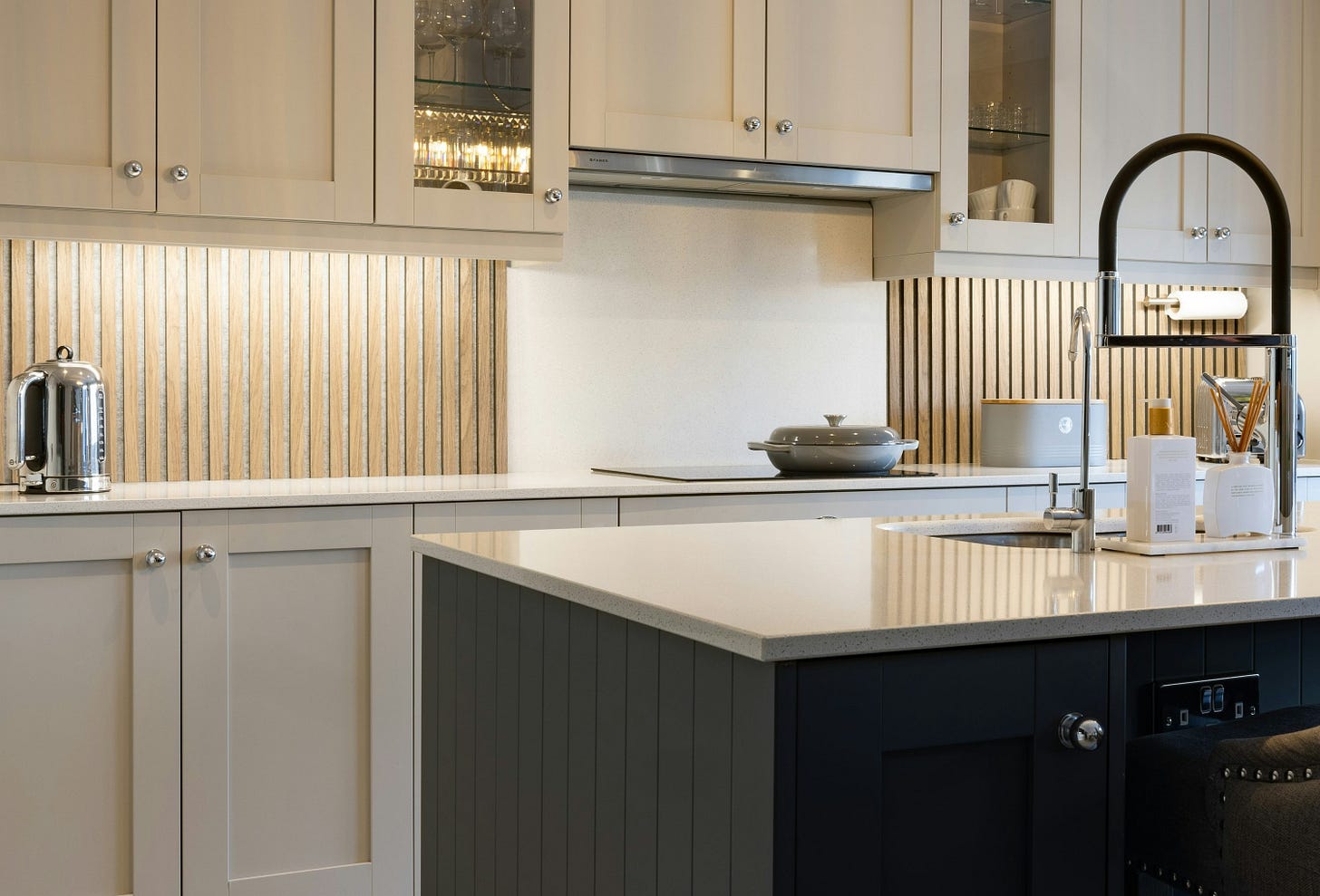 a kitchen with white cabinets and a black island