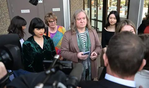 EPA Roxanne Tickle (centre) looks on as she is surrounded by people while speaking to press outside the Federal Court of Australia in Sydney on 23 August.