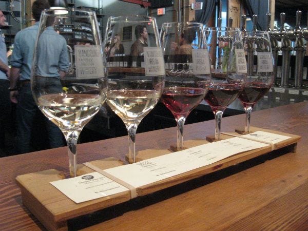 a group of five wines ready for tasting at the wine bar. Tasting is one of the onboard cruise activities.
