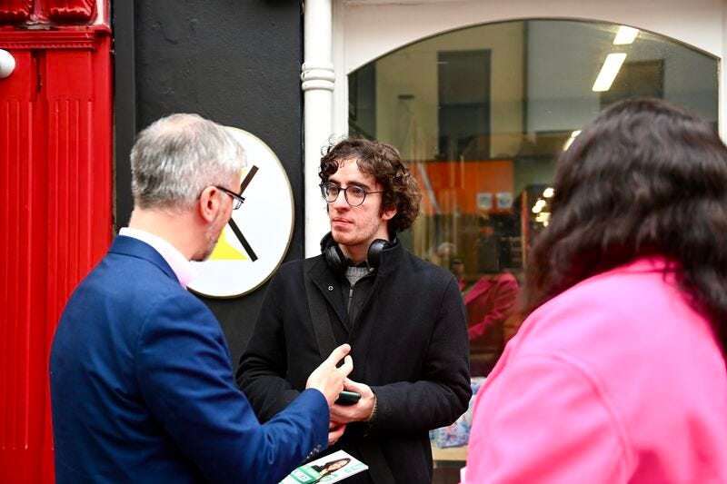 Me talking to Roderic O’Gorman (left of the photo) on Oliver Plunkett street outside a shop. To the right of me is Monica Oikeh with her back to the camera.