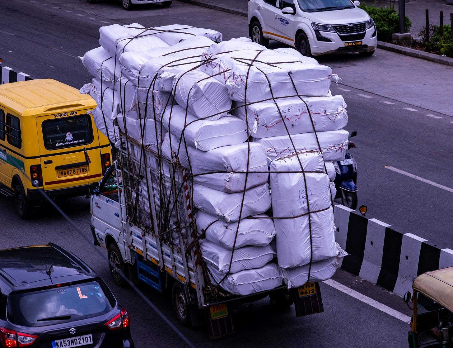 An overloaded truck on a busy road