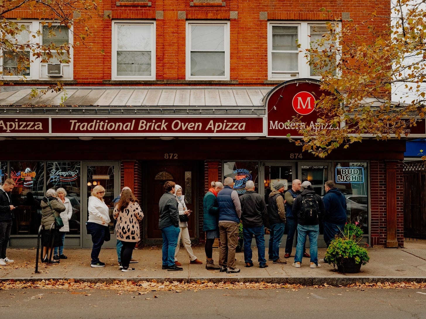 A line of people waiting outside Modern Apizza.