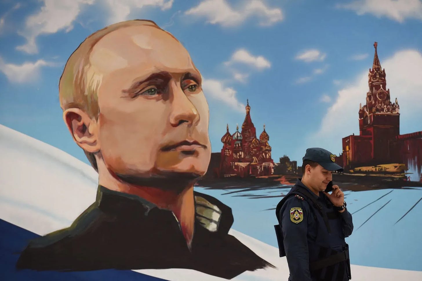 A Russian rescuer speaks on his mobile phone next to a wall bearing an image of Russian President Vladimir Putin and Moscow’s Kremlin at a polling station during local elections organized by the Russian-installed authorities in Donetsk, Russian-controlled Ukraine.