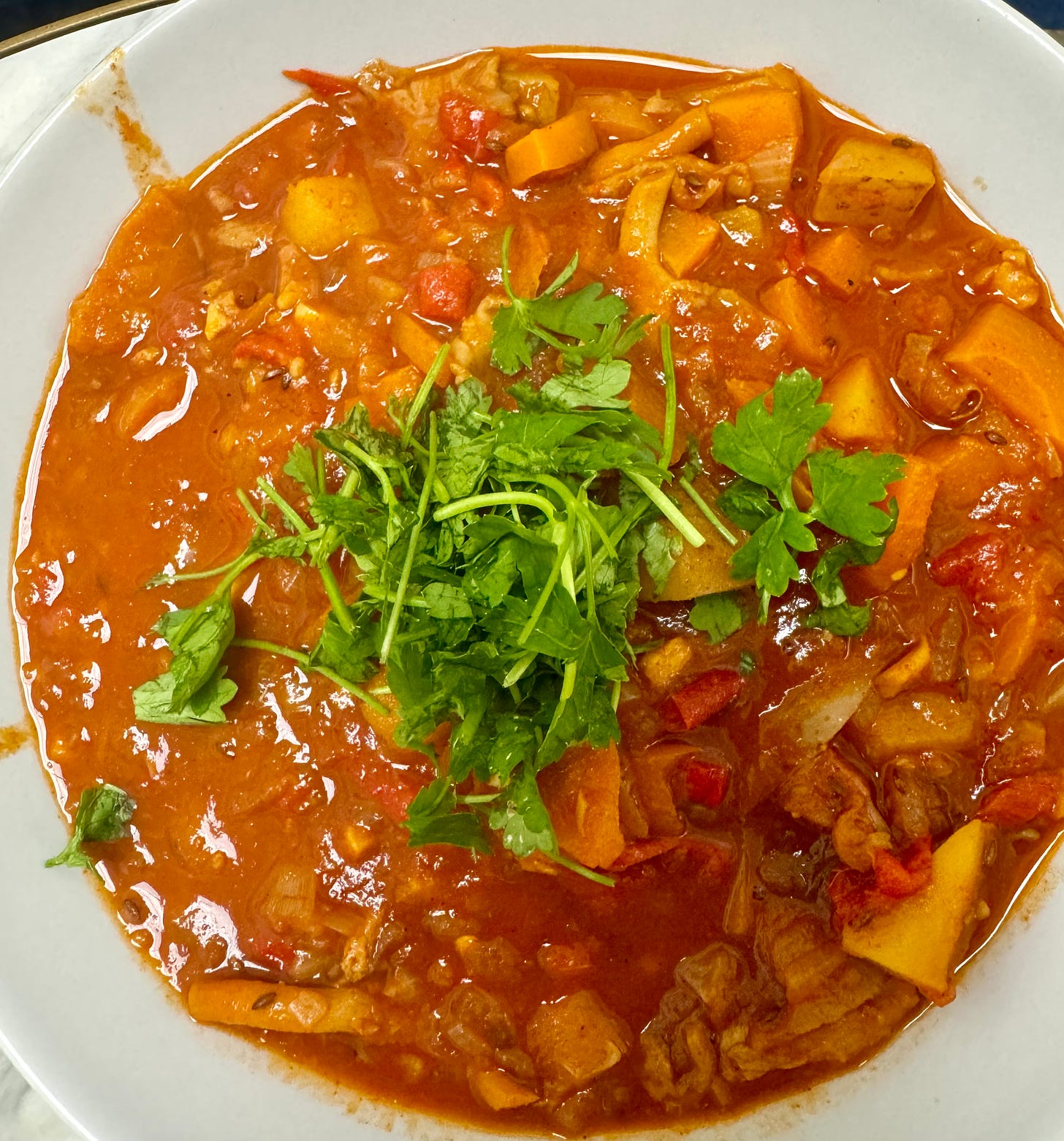 Bowl of Hungarian Plant-Based Goulash with Chopped Parsley On Top