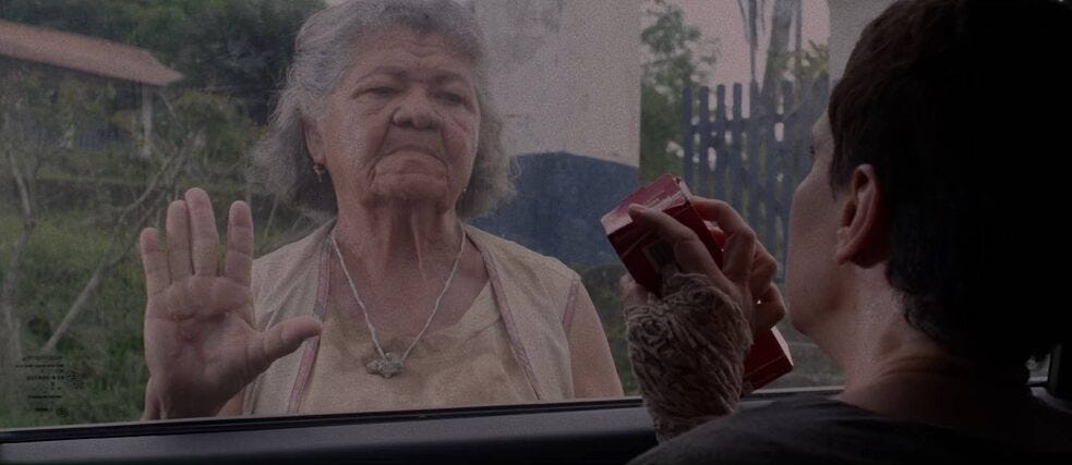 Descrição da Imagem: Cena do filme Propriedade em que a atriz Maria José Sales encara Theresa, vivida por Malu Galli, através da janela do carro. 