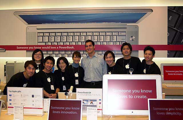 Steve Cano stands with employees at the opening of Apple Ginza.