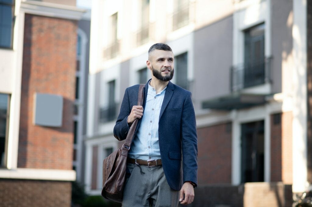 Man with brown leather handbag walking to the office