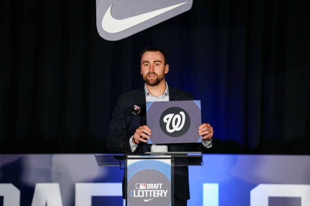 Colton Cowser announces the Washington Nationals as winners of the number one pick during the Draft Lottery at the 2024 MLB Winter Meetings at Hilton...