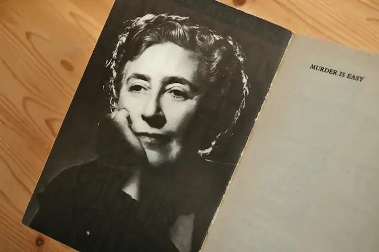 A photo of the novelist Agatha Christie from the inside of her book 'Murder is Easy' lying on a wooden table.